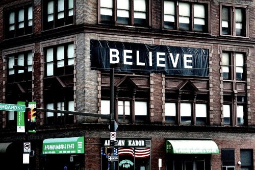 banner reading BELIEVE hanging from building